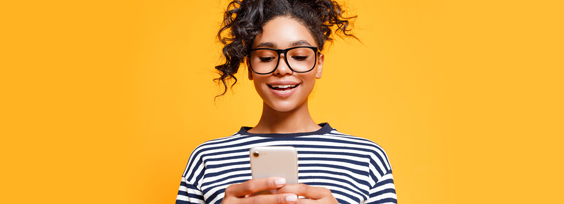 Mujer Joven Sonriente Revisando Redes Sociales en su Smartphone